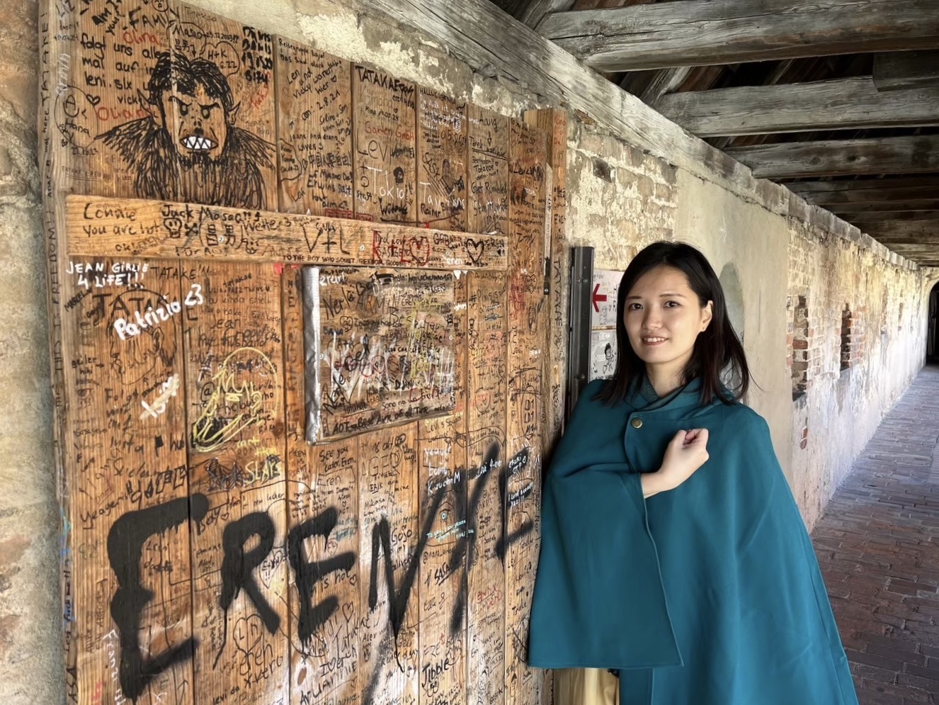 ▲『進撃の巨人』のファンが訪れる聖地で「調査兵団マント」をまとい記念撮影。現地のファンからも声をかけられたそうです